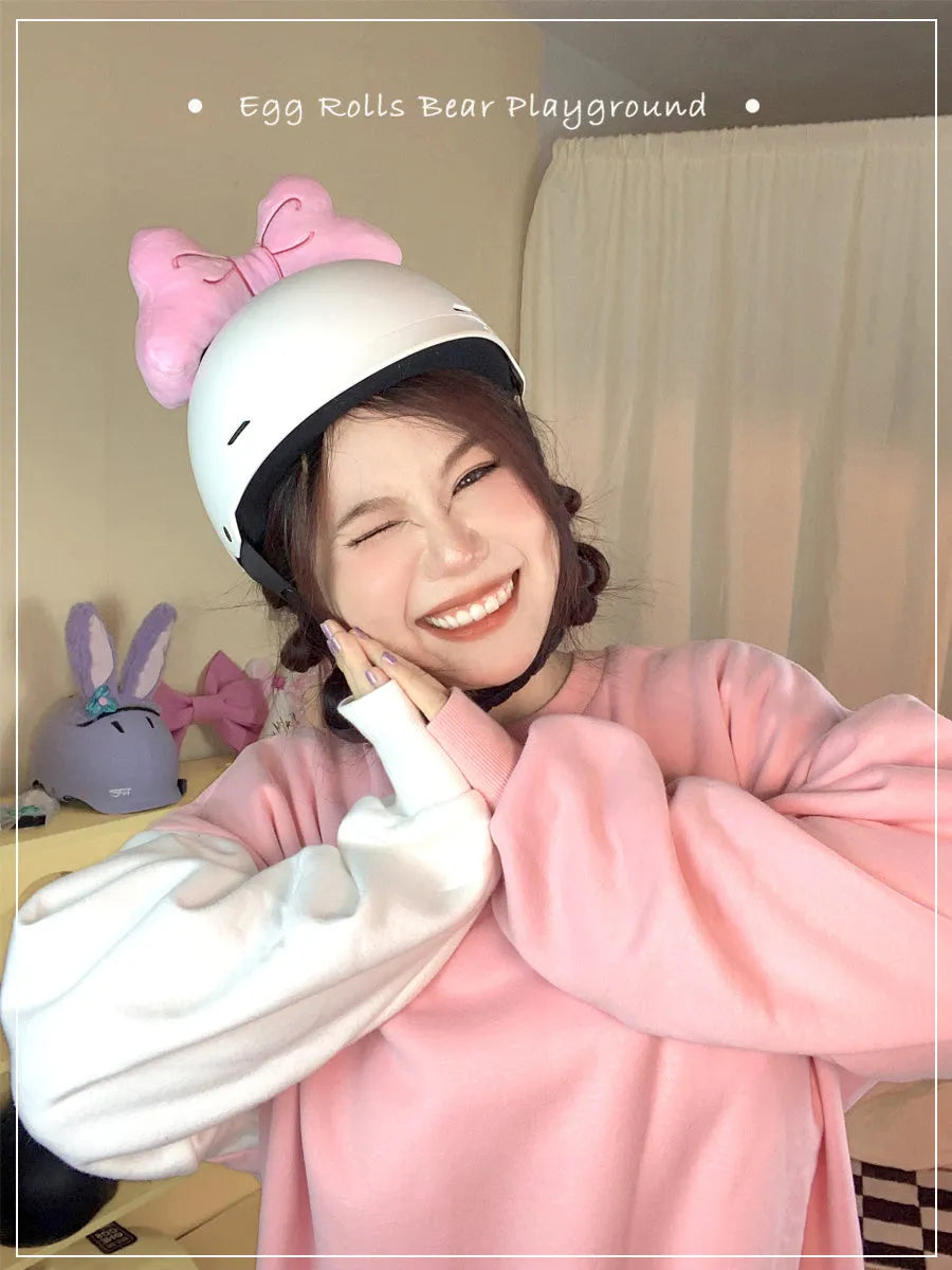 Soft plush bow helmet decoration with pom-pom in red, pink, and peach colour options.