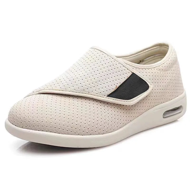 Beige and grey leisure shoes with a wide fit and a black velcro strap closure.