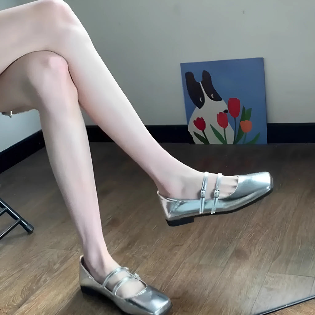Women's silver leather ballet pumps with a cross buckle strap and flat heel