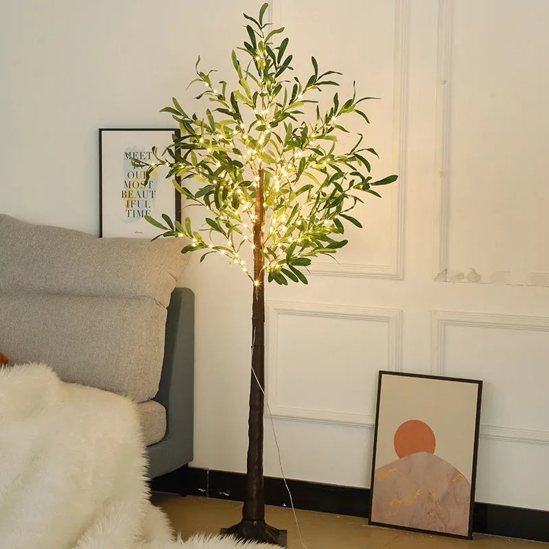 Tall 1.8m artificial olive tree lamp with warm white LEDs illuminating simulation leaves in a courtyard setting.