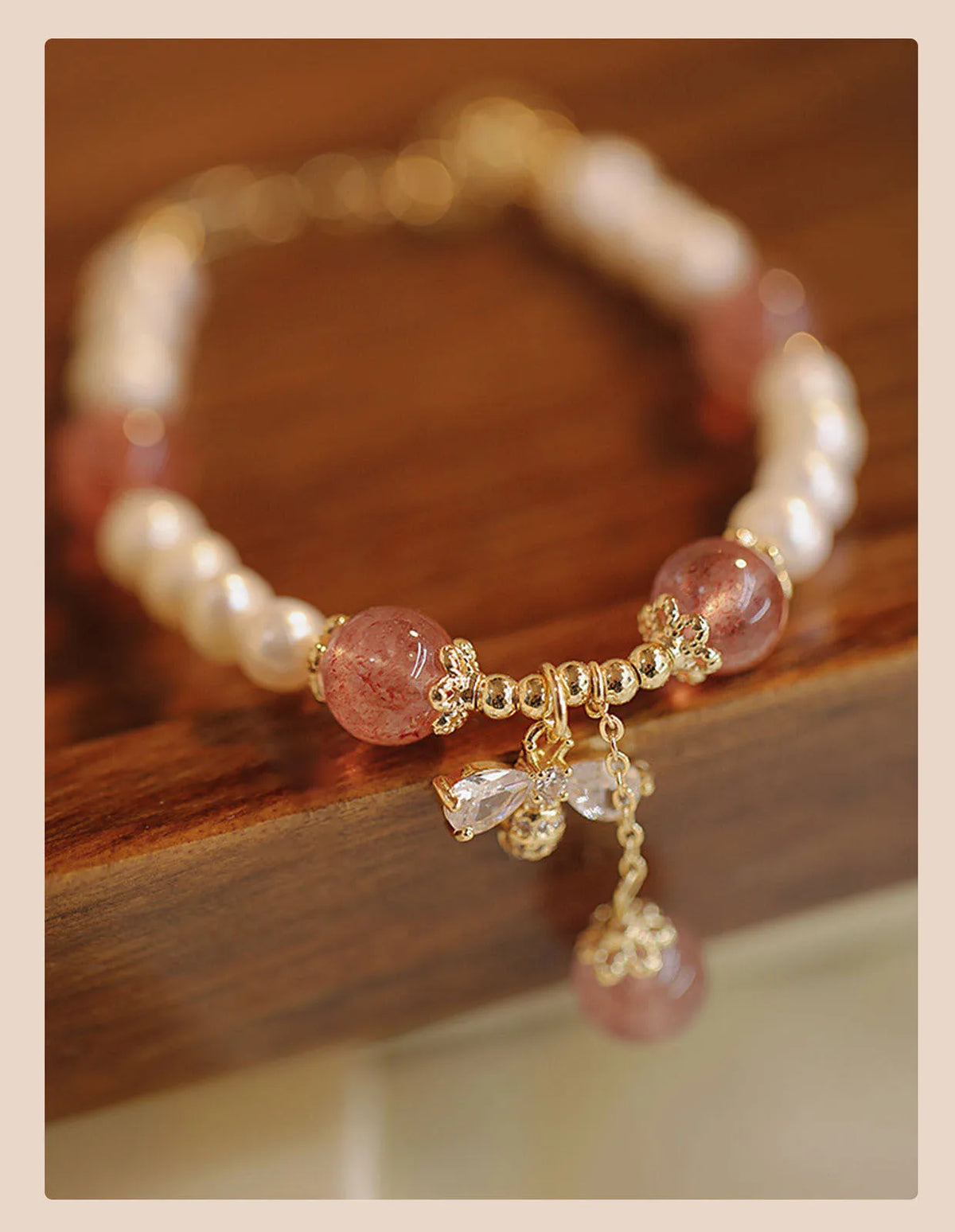 Strawberry quartz crystal bracelet with stringed pearls and bow detail