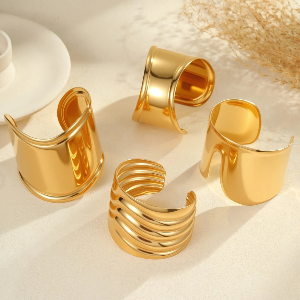 Gold-plated stainless steel wide bracelet with wave geometric design and a niche opening.