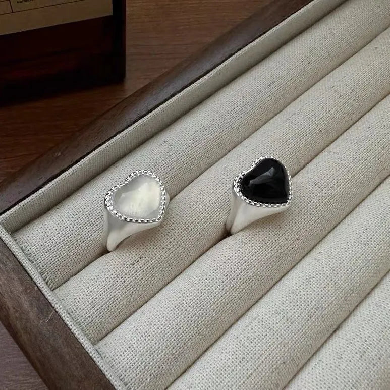 Sterling silver adjustable ring with black agate heart design on model's hand