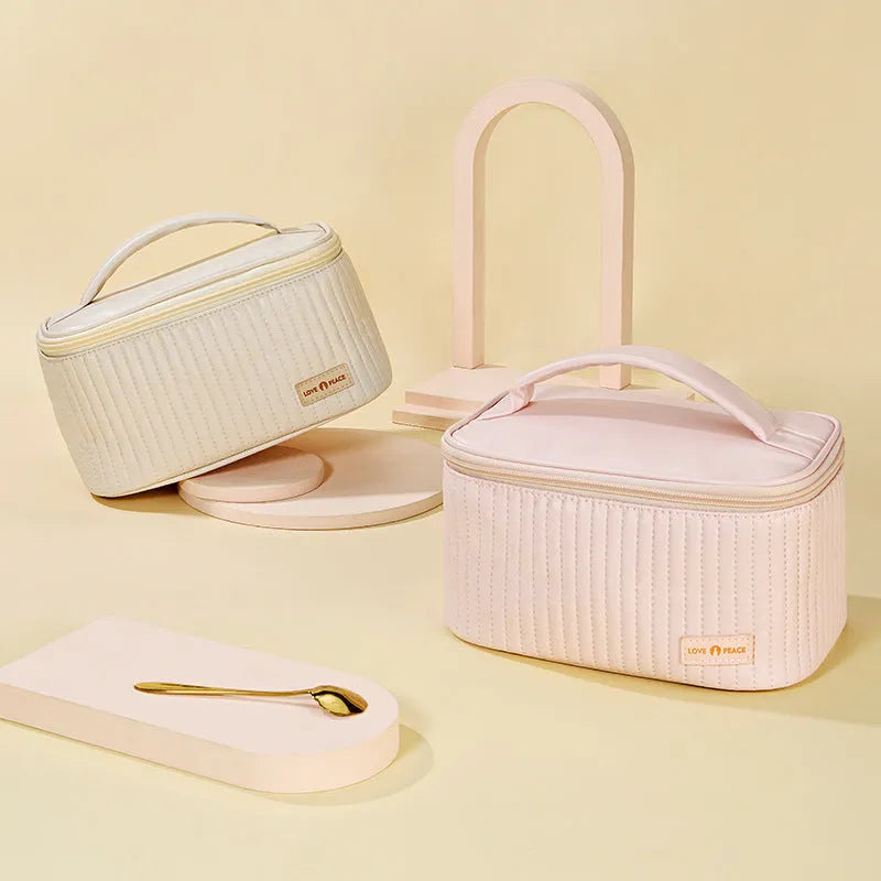 Open-top cake-shaped makeup bag in PU leather shown in a light colour, demonstrating its structured shape and easy-access design.