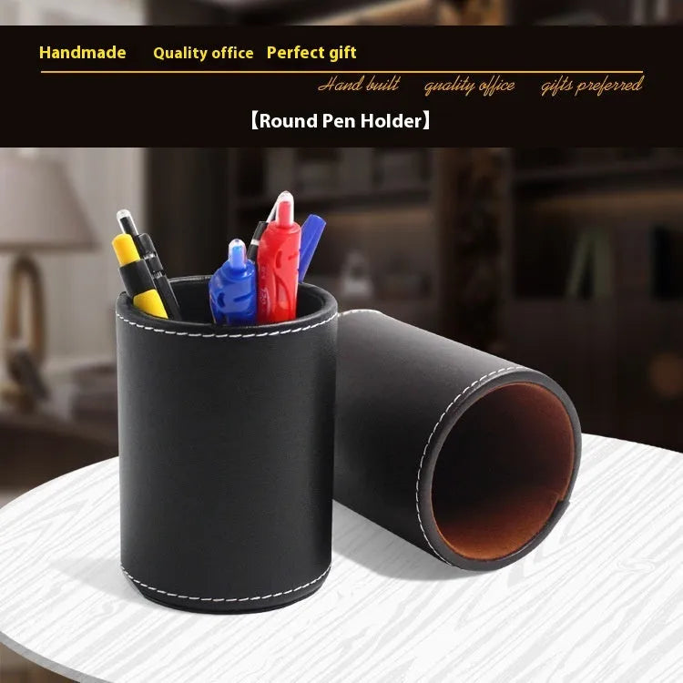 Small round black leather pen holder container on a desk