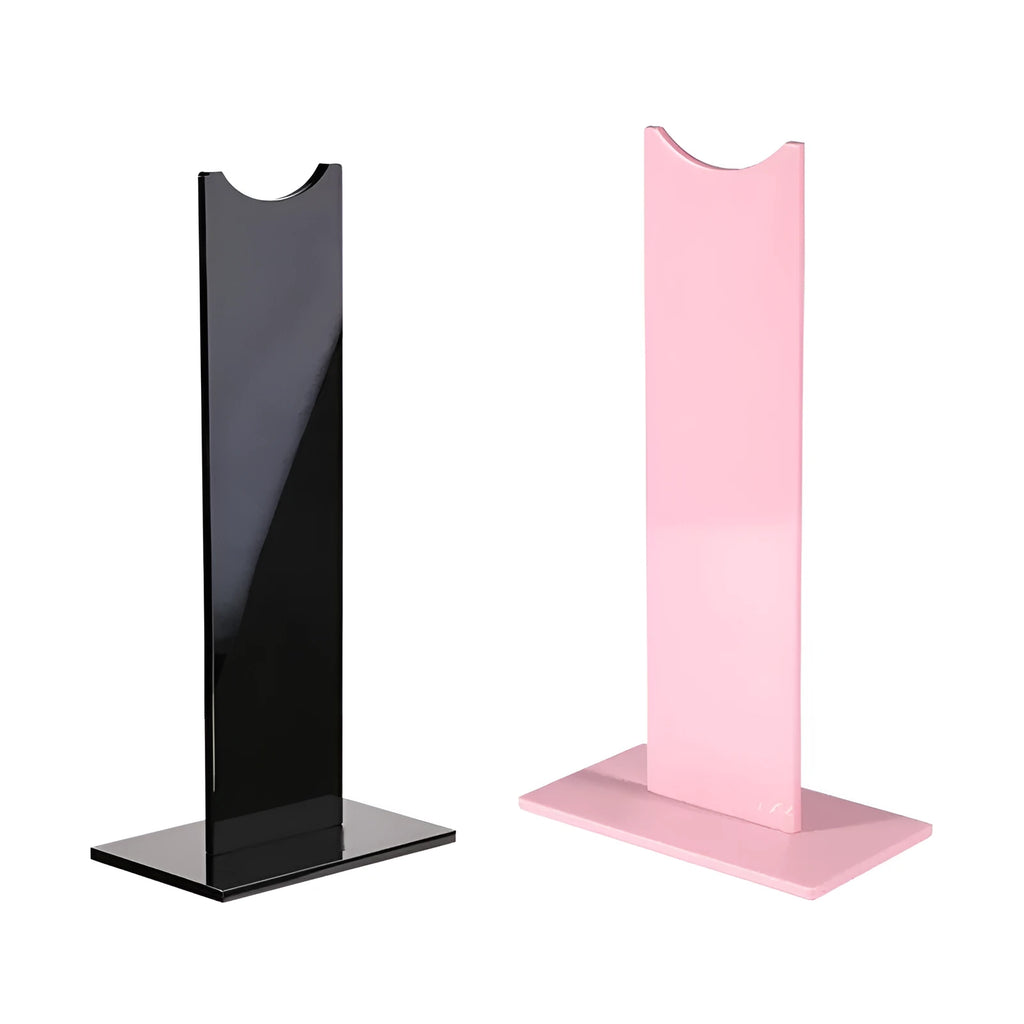 Pink and black detachable headphone stand with silicone base on a desk.