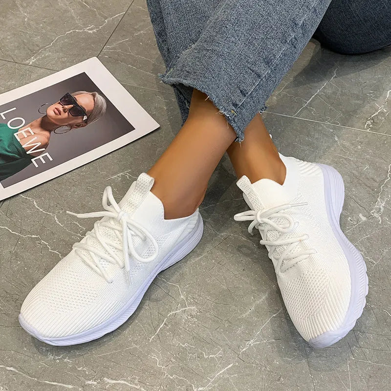 Women's low-top mesh running shoe in creamy white with a round toe and flat rubber sole.