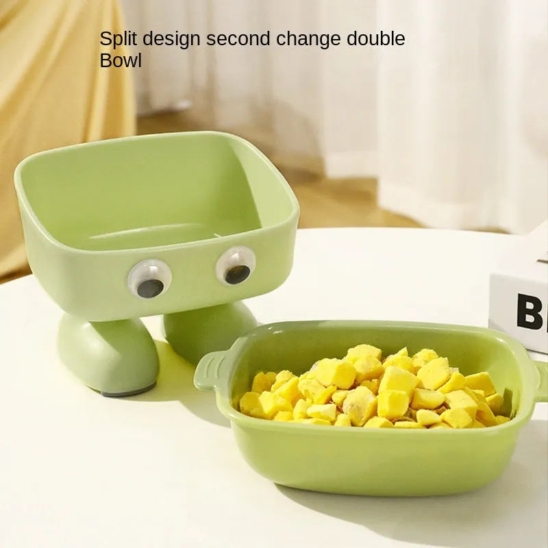 Green cartoon robot shaped elevated cat bowl with tilted food dish on anti-slip base