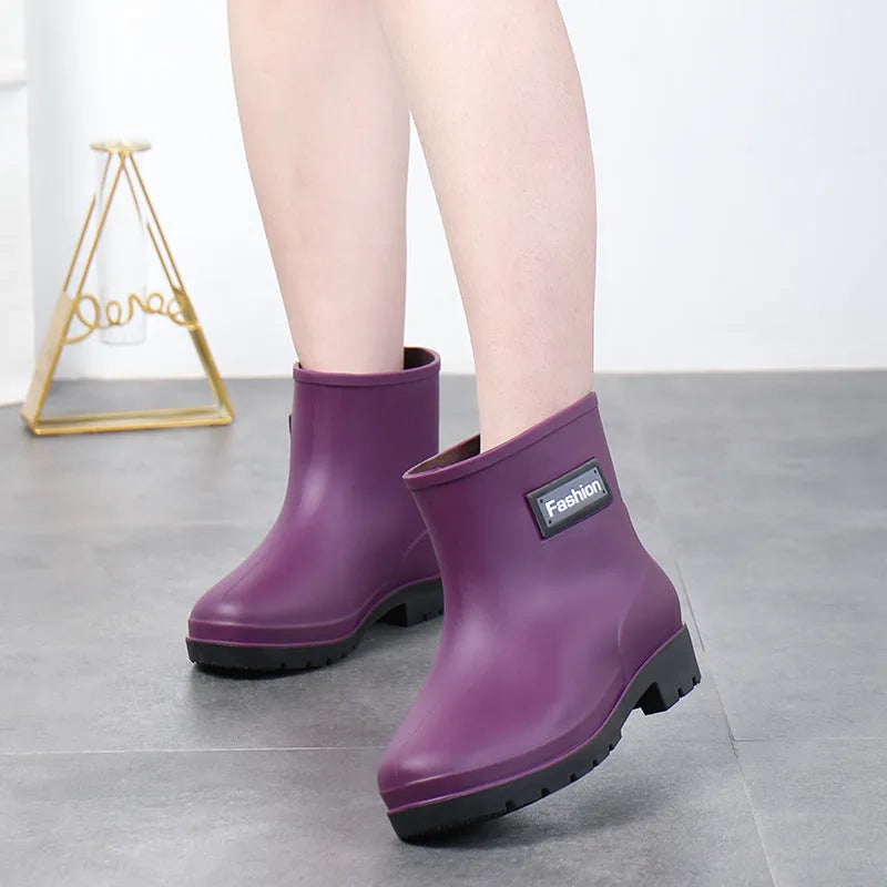 Women's mid-calf PVC rain boot in black on a wet surface