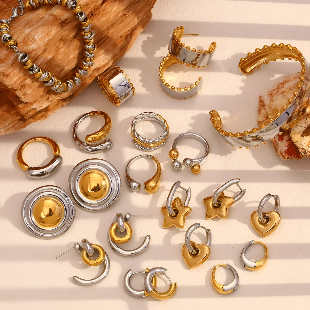 Ladies gold tone geometric jewellery set with earrings, bracelet and necklace on white background.