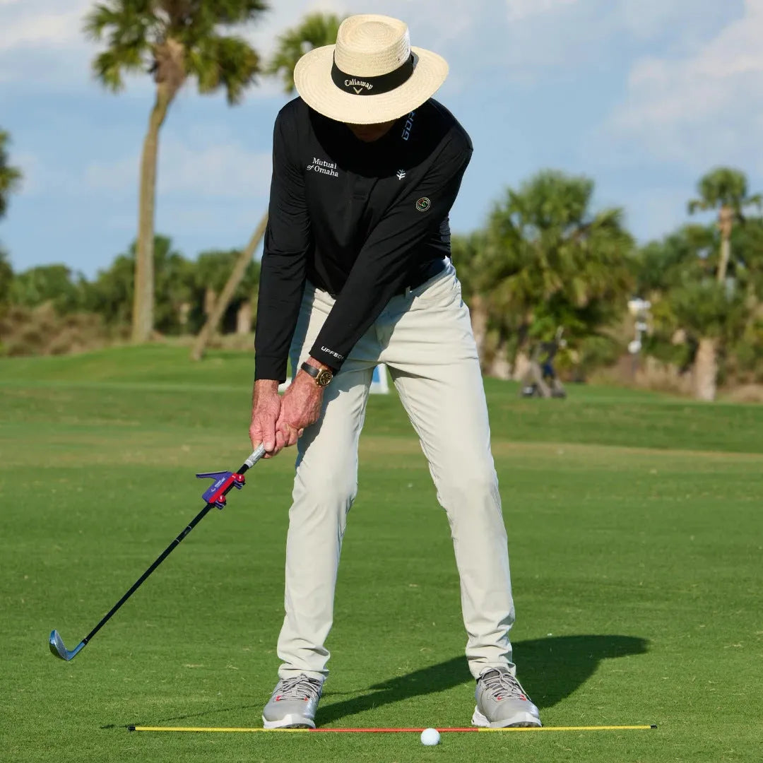 Plastic golf swing plane training simulator on a green background