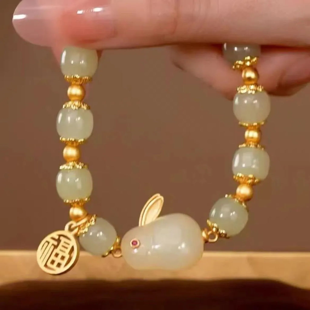 Women's green jade bracelet with black hand charm and hare pendant featuring fu character and lily motifs
