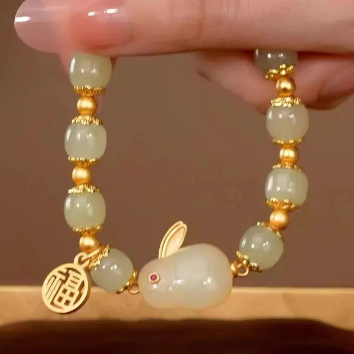 Women's green jade bracelet with black hand charm and hare pendant featuring fu character and lily motifs