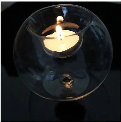 Clear hollow glass spherical candle holder in European style on a table.