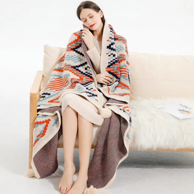 Acrylic sofa blanket with tassel fringe in neutral beige tone on grey sofa