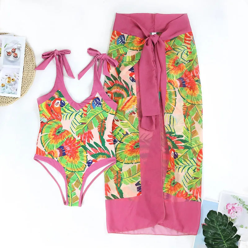Pink floral print women's V-neck one-piece swimsuit with a thin skirt.
