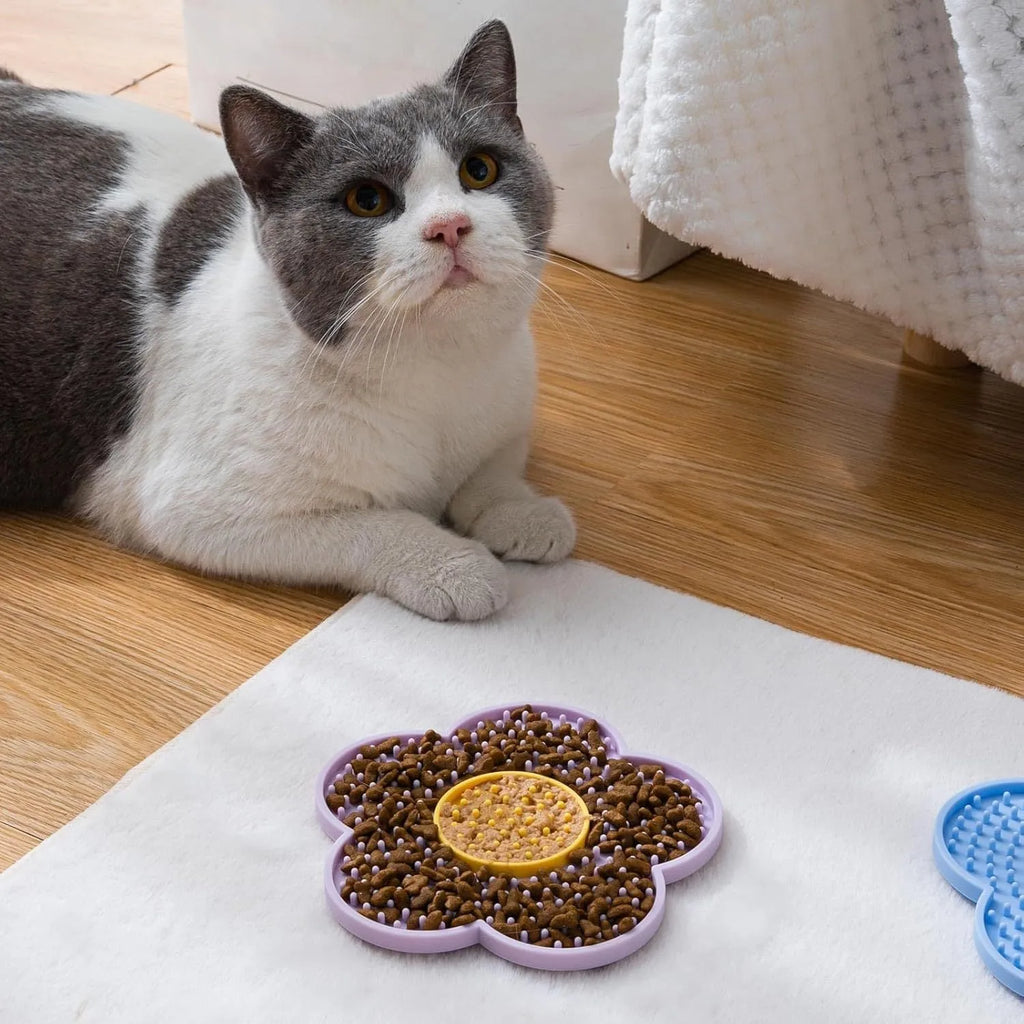 Flower-shaped blue silicone pet lick mat with suction cups on a tiled floor.