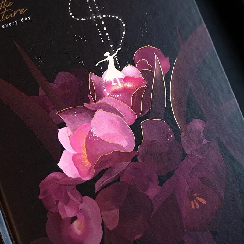 A5 notebook with luminous cover open to show colour illustrated pages, available in four colours.