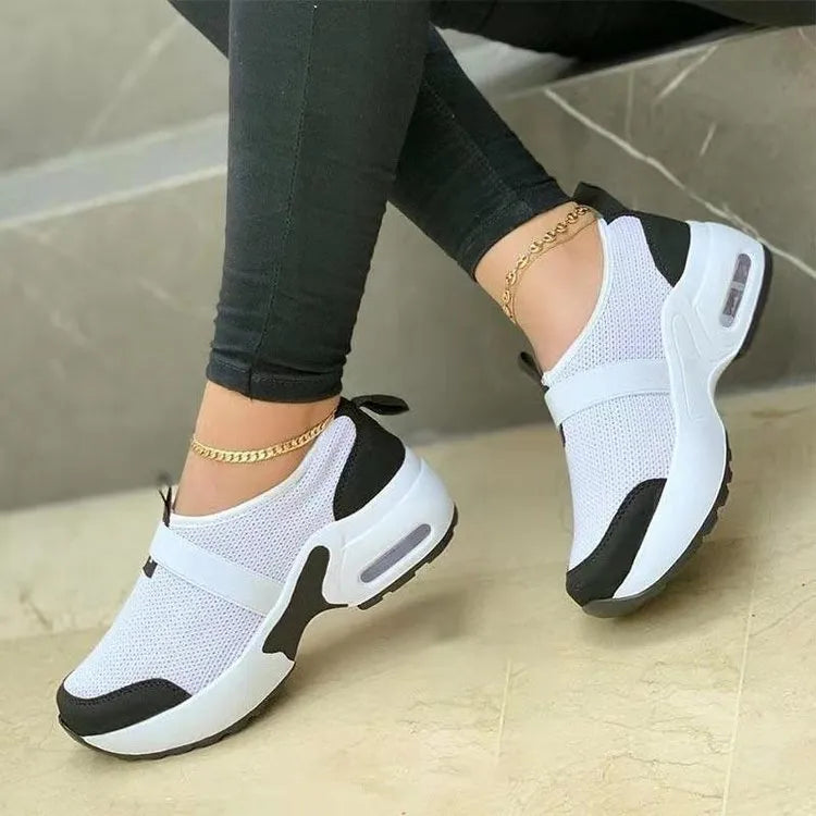 Women's flat sneakers in light grey with mesh upper, round toe, and rubber sole.