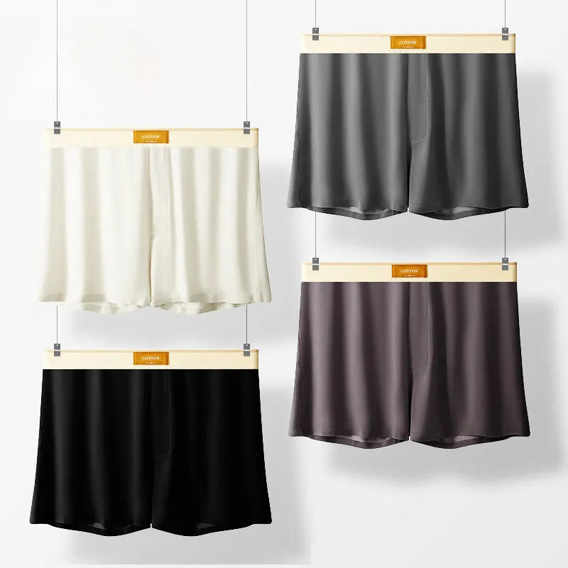 Three pairs of men's solid colour ice silk briefs on a grey background.