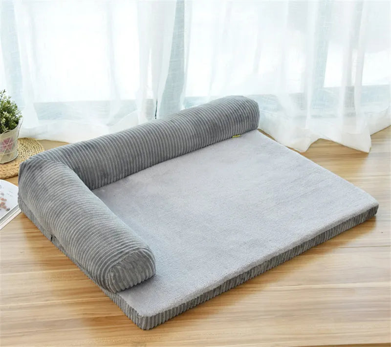 Grey corduroy dog sofa bed with bilateral bolsters on a wooden floor.