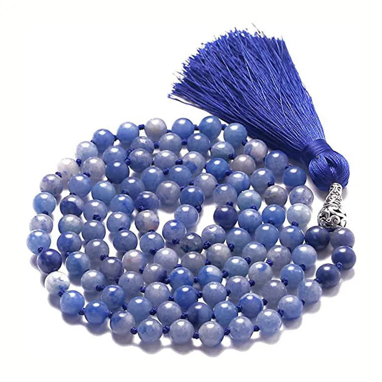 Long blue patterned agate and stone tassel necklace with geometric beads on a white background.