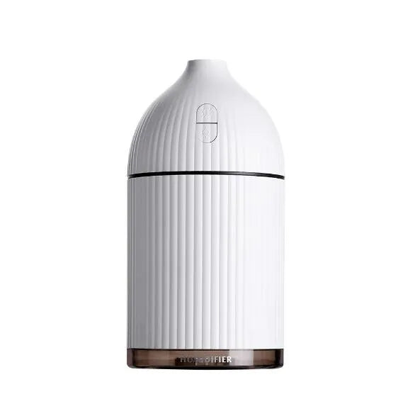 White ultrasonic aromatherapy diffuser humidifier with USB cable and LED light on wooden table