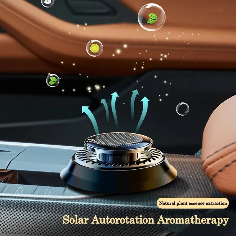 Solar powered kinetic car air freshener with rotating double rings on a black plastic base.
