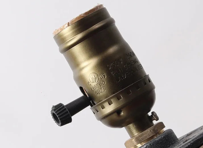 Compact wooden and iron water pipe table lamp on a table surface