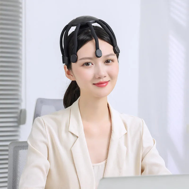 Black electric head massager with eight silicone-tipped claws extending from central handle