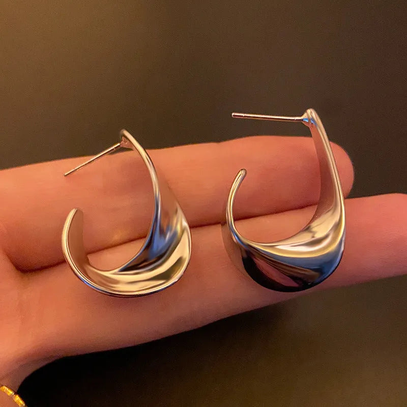 Geometric metal earrings with twisted design and round elements in gold electroplated finish