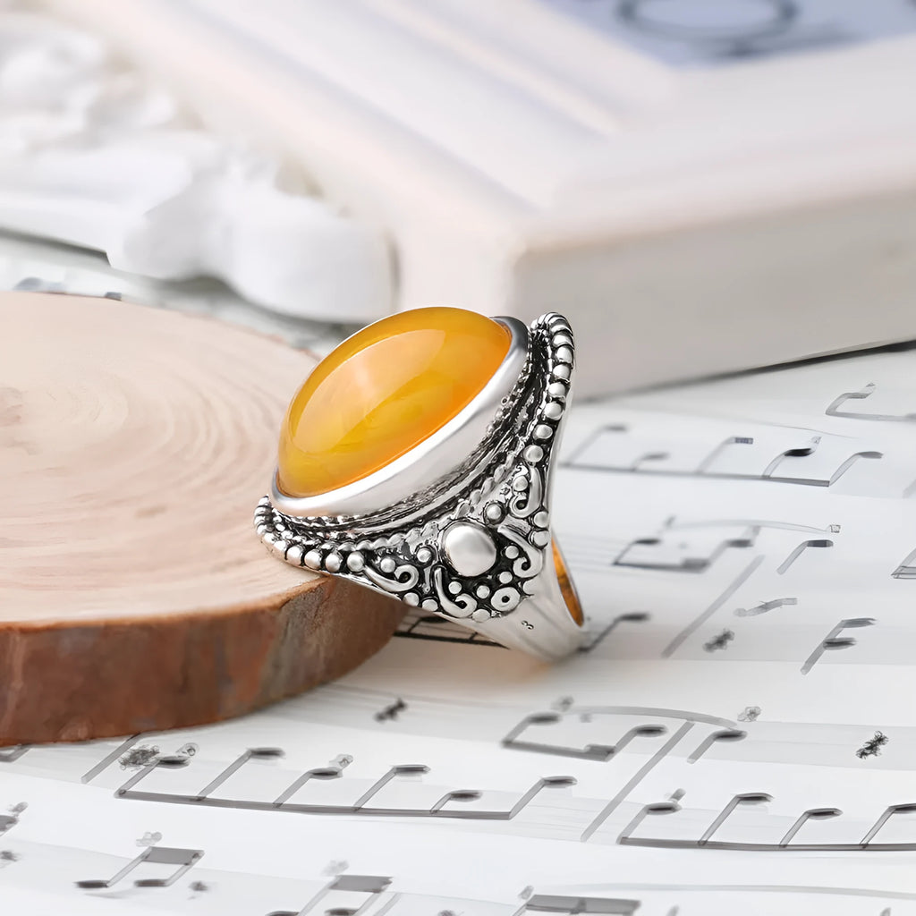 Geometric retro-style alloy ring in antique silver amber colour on a finger.