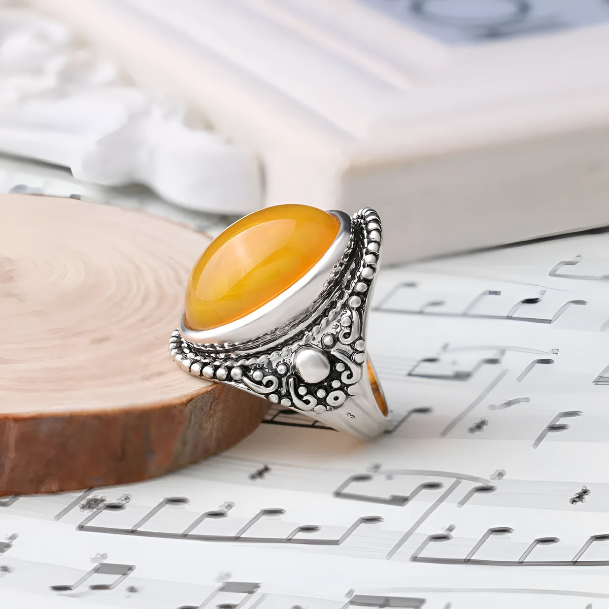 Geometric retro-style alloy ring in antique silver amber colour on a finger.