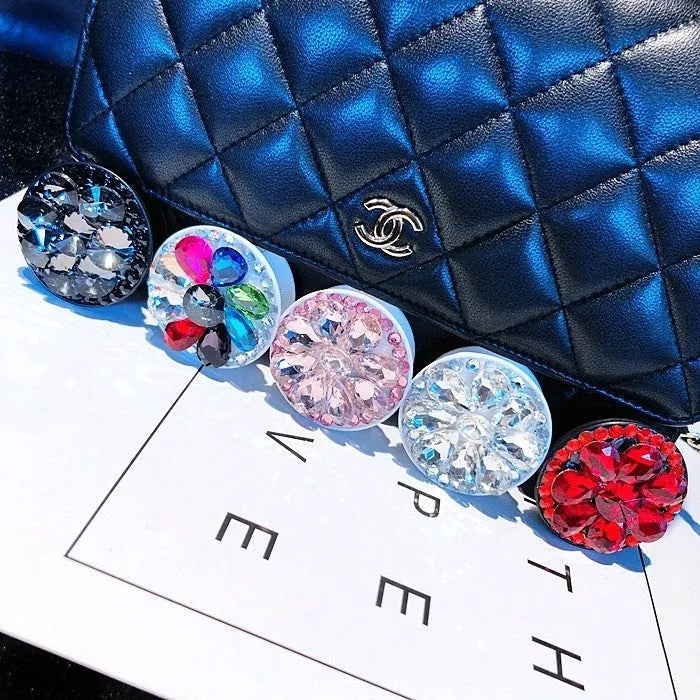 Rhinestone airbag mobile phone holder with telescopic bracket, shown in one of seven colour options for hands-free viewing.