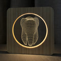 Tooth-shaped wooden-coloured acrylic night lamp with USB cable on wooden surface