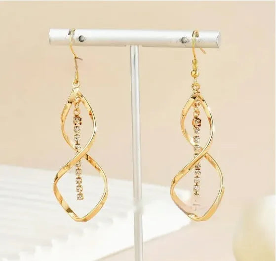 Gold geometric spiral earrings with ellipse design elements on alloy construction