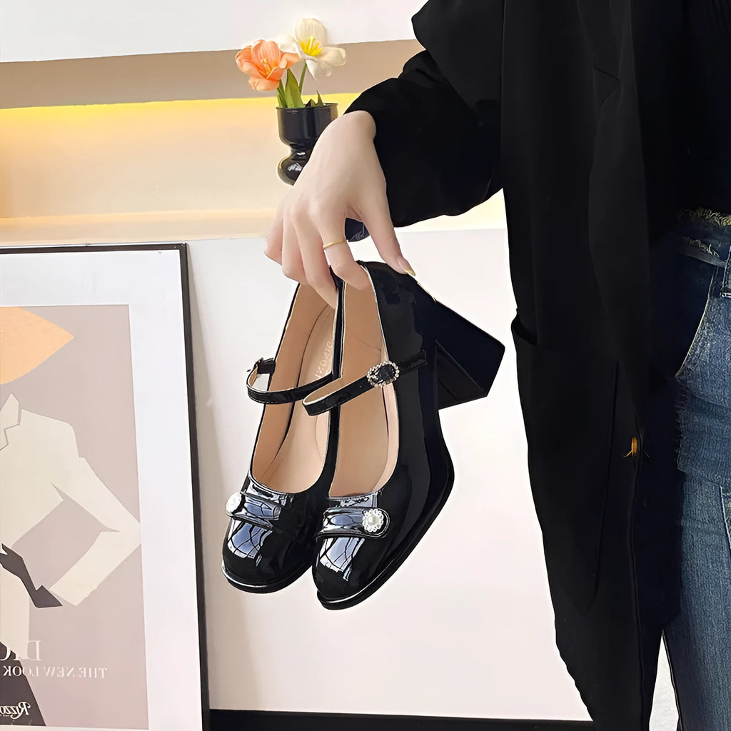 Women's black patent leather chunky heel high shoes with round toe and buckle.