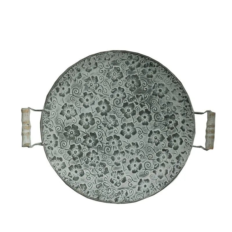Round wrought iron storage tray in two sizes on a wooden surface.