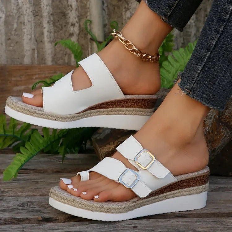 White casual wedge sandals with woven patent leather upper and peep toe design on a foot.