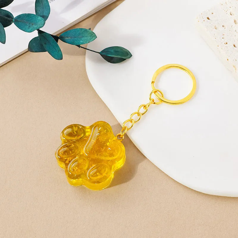 Small handcrafted crystal cat's paw shaped keychain pendant on a keyring.