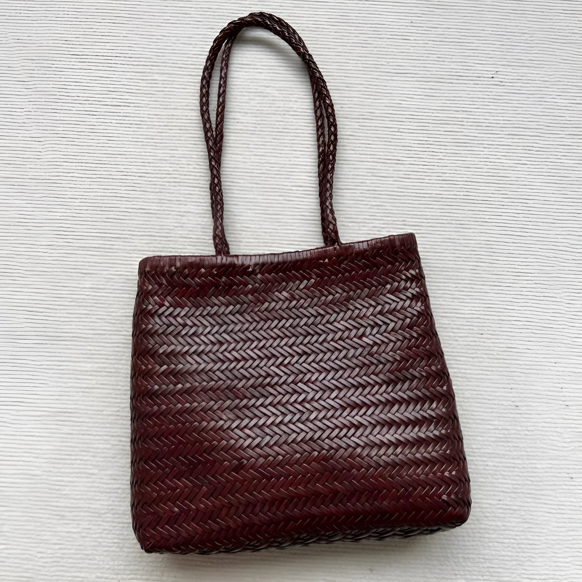 Brown handmade woven tote bag with three-dimensional pocket design and cowhide leather construction