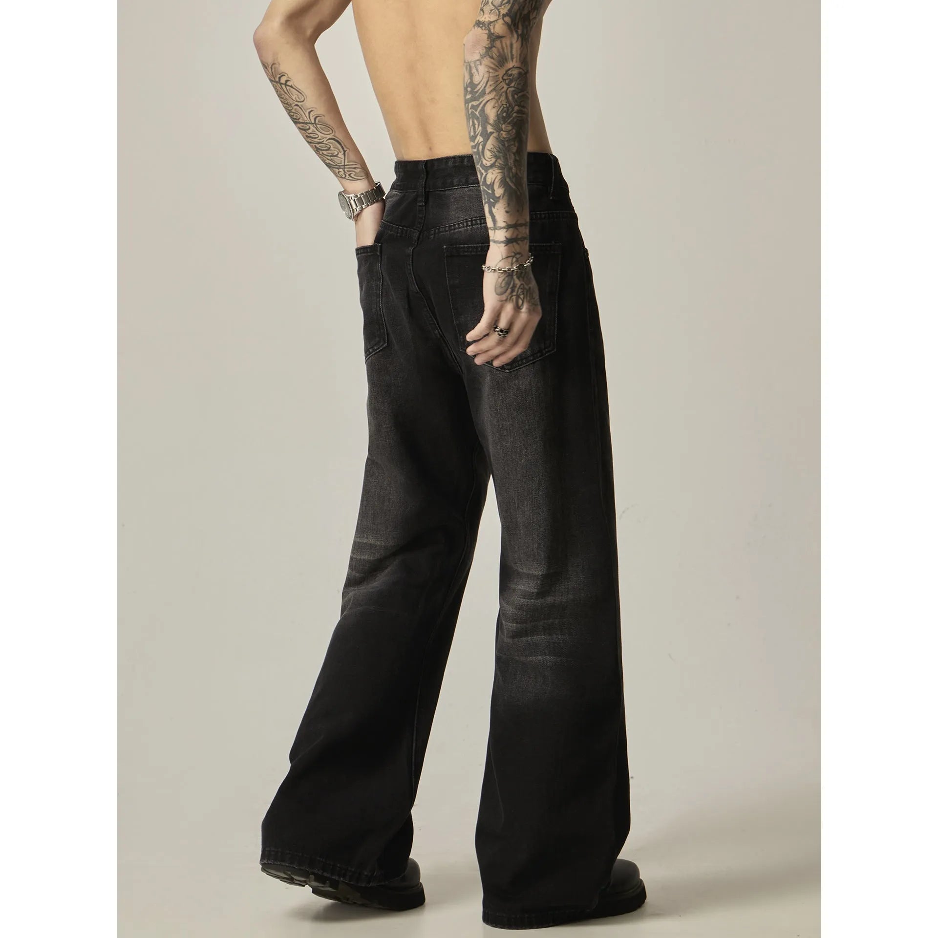 Black loose-fit straight-leg retro jeans with a zipper fly on a mannequin.