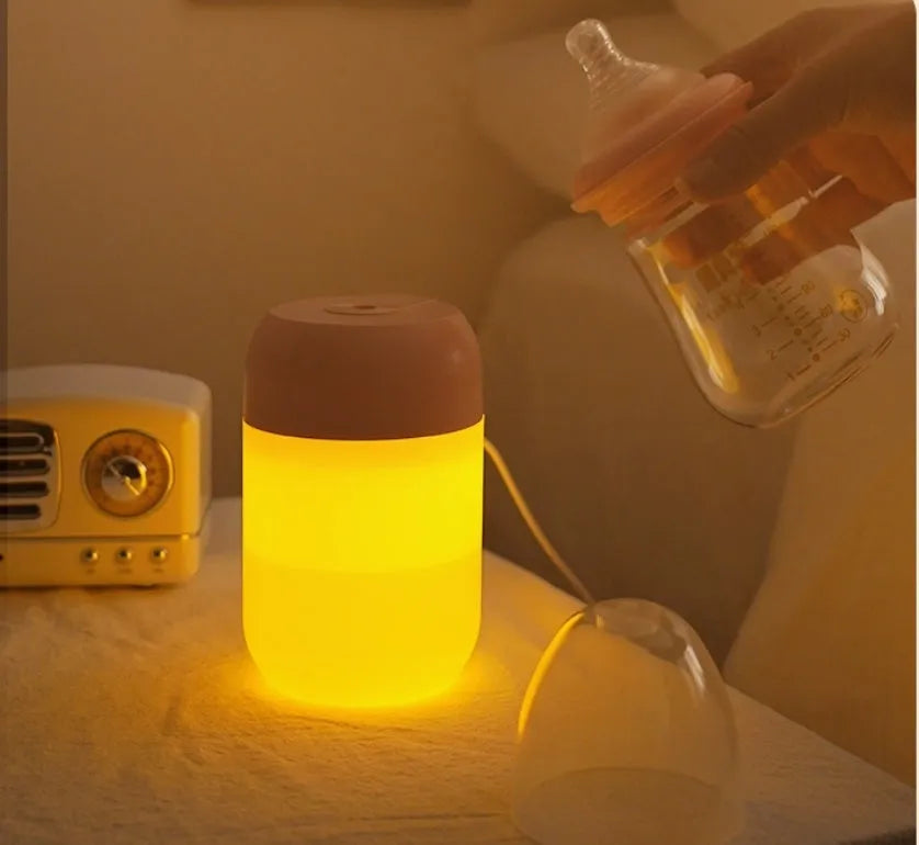White cylindrical mini humidifier with USB cable on a desk