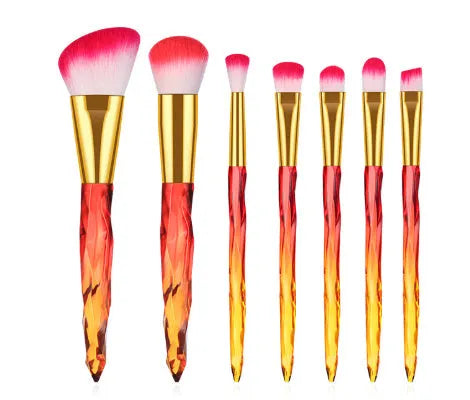 Ten clear crystal-handled foundation brushes with artificial fibre bristles, laid out in a set.