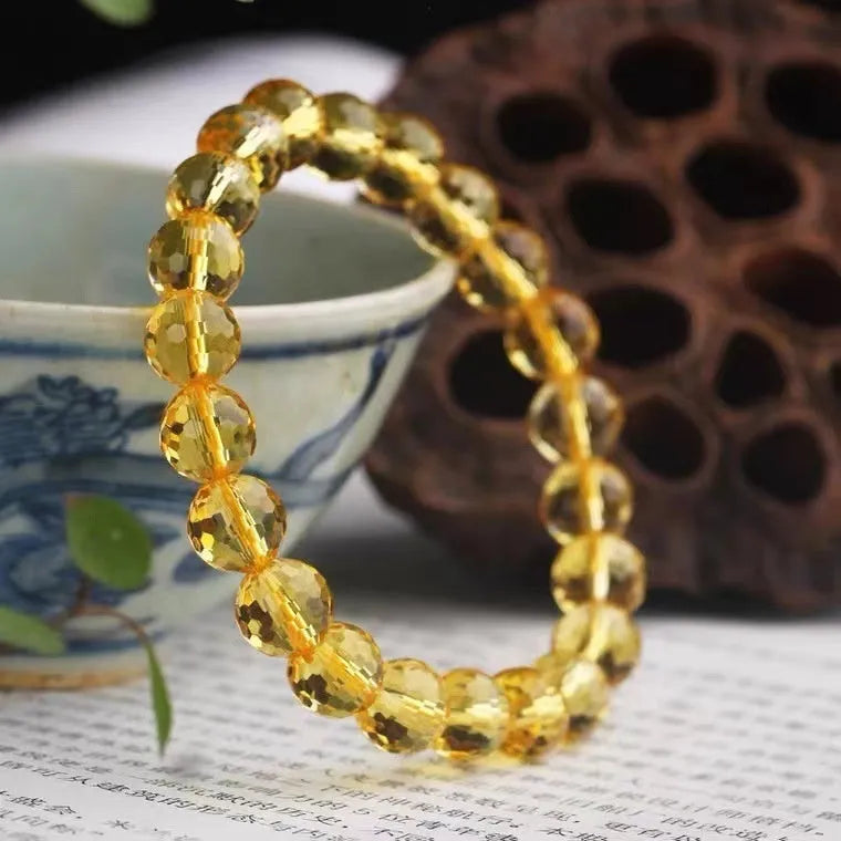 Hand-crafted ametrine bracelet with 128-facet cut crystal beads on a wrist.