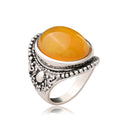 Geometric retro-style alloy ring in antique silver amber colour on a finger.