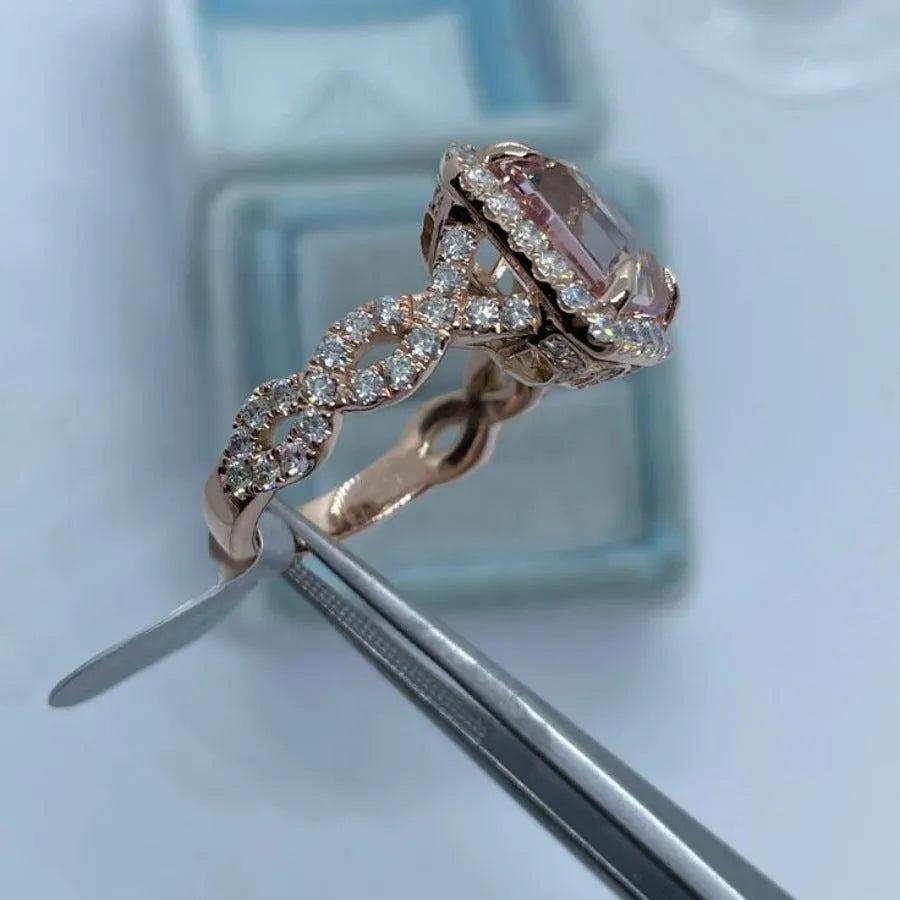 Geometric rose gold coloured alloy ring on a plain background.