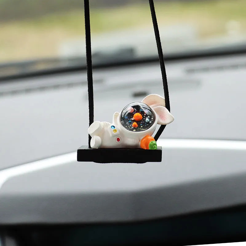 Resin astronaut car pendant showing five colour options including telescope and red flag designs