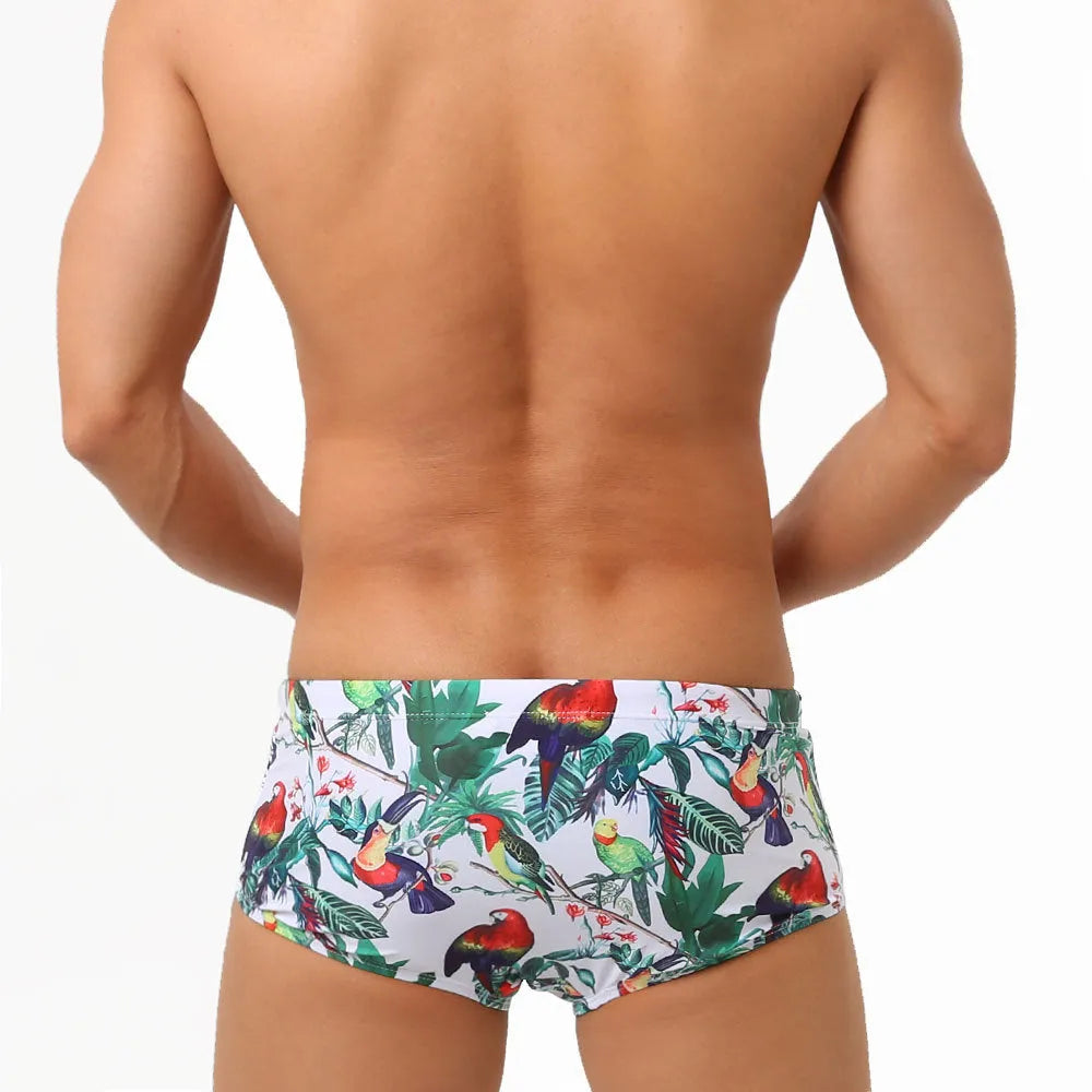 Men's floral bird print nylon swim trunks in boxer style on white background