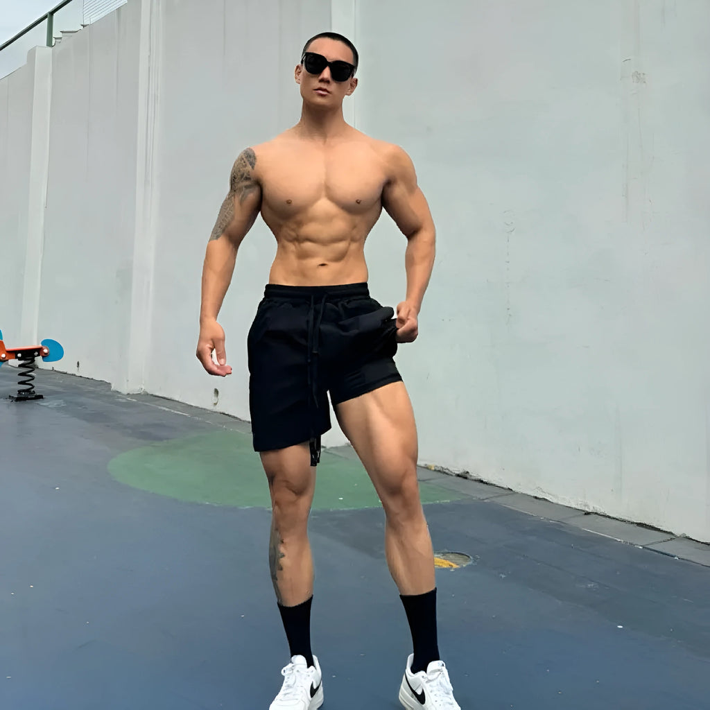 Men's black quick-drying nylon shorts with a double-layer casual design on a hanger.